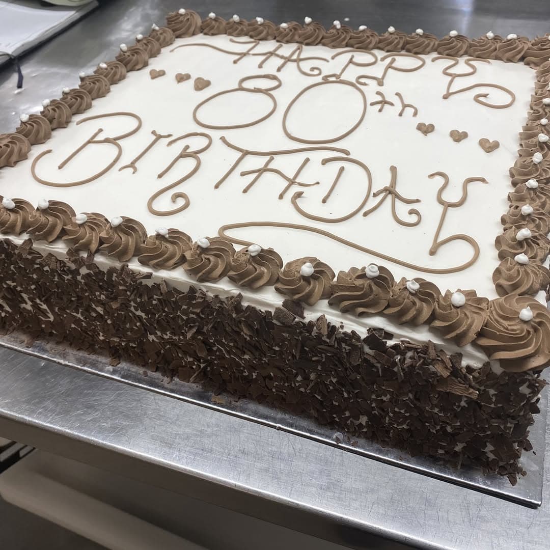 A large 80th birthday slab cake with chocolate shavings, made in the bakery